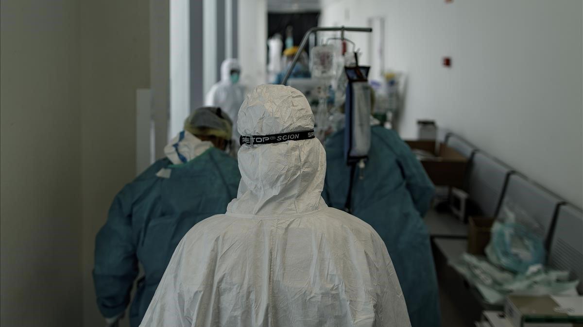 Personal sanitario totalmente equipado traslada a un paciente ingresado en la Unidad de Cuidados Intensivos del Hospital Infanta Sofia en San Sebastián de los Reyes (Madrid), el pasado 28 de abril.