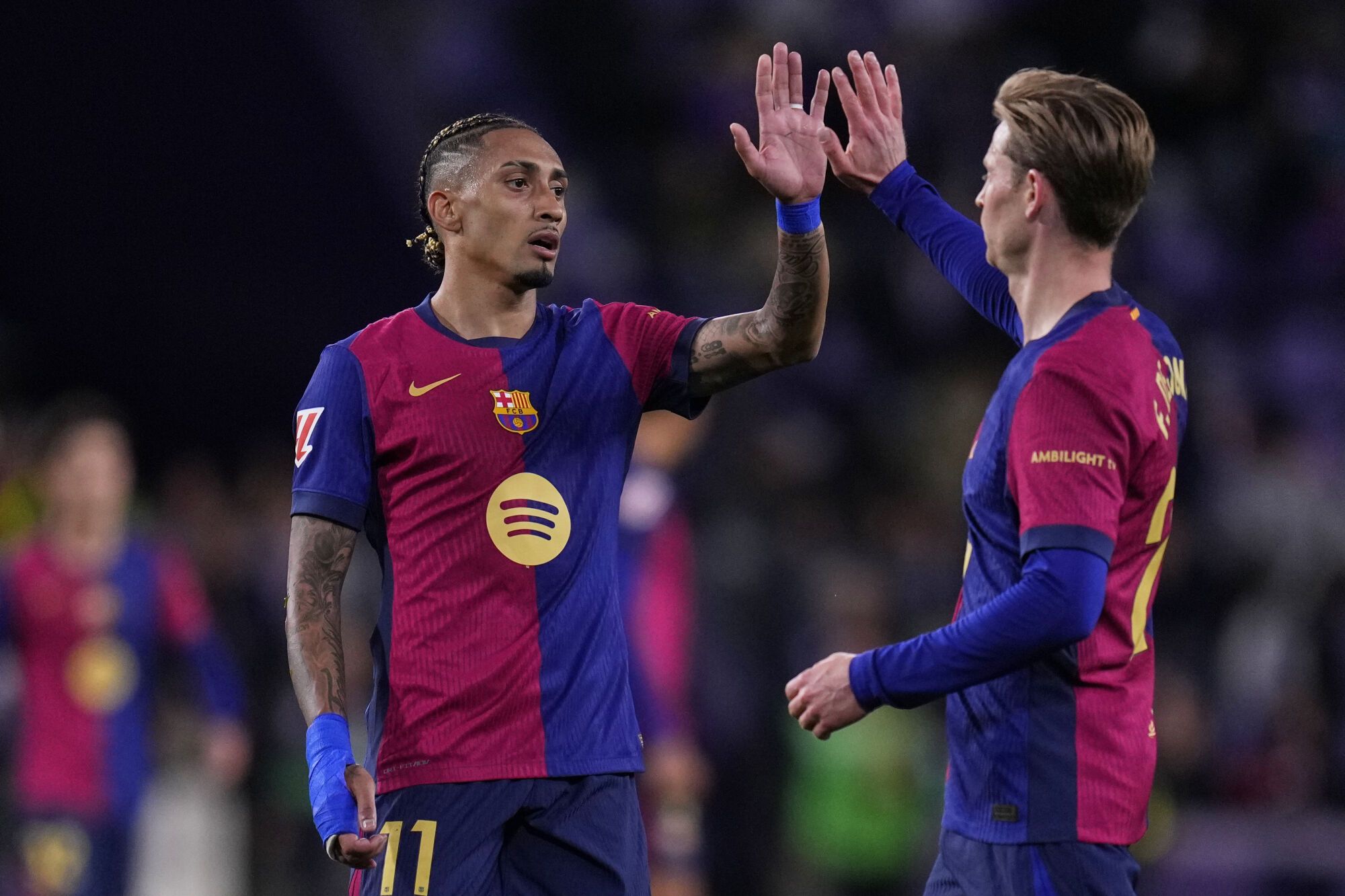 Barcelona's Raphinha, left, and Barcelona's Frenkie de Jong celebrate after the Spanish La Liga soccer match between Valladolid and FC Barcelona at the Jose Zorrilla stadium in Valladolid, Spain, Saturday, May 3, 2025. (AP Photo/Manu Fernandez)