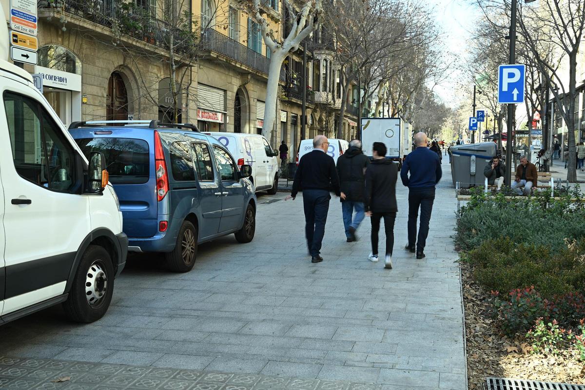 Vehículos estacionados en Girona y, a la derecha, una de las señales que indican el giro obligatorio, no siempre respetado.