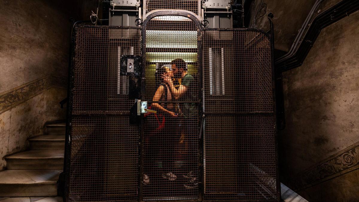 Una pareja en un ascensor de un bloque de viviendas en Barcelona.