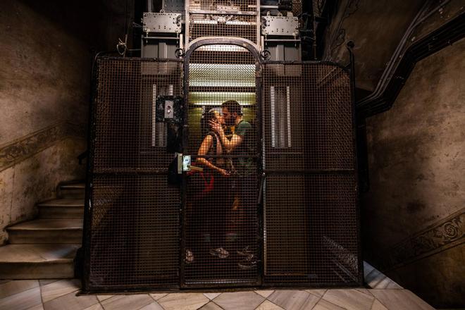 Una pareja en un ascensor de un bloque de viviendas en Barcelona.