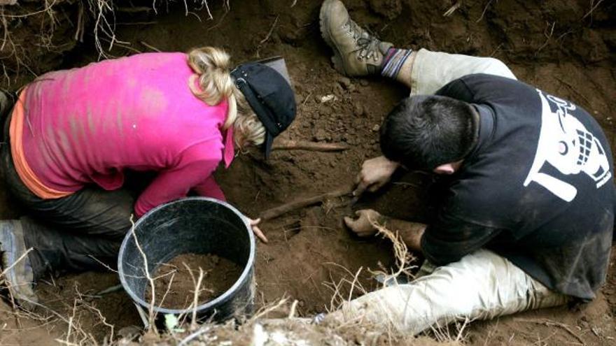 Dos arqueólogos de la ARMH, en agosto de 2007, durante la exhumación de una fosa en O Pino. / lavandeira jr.