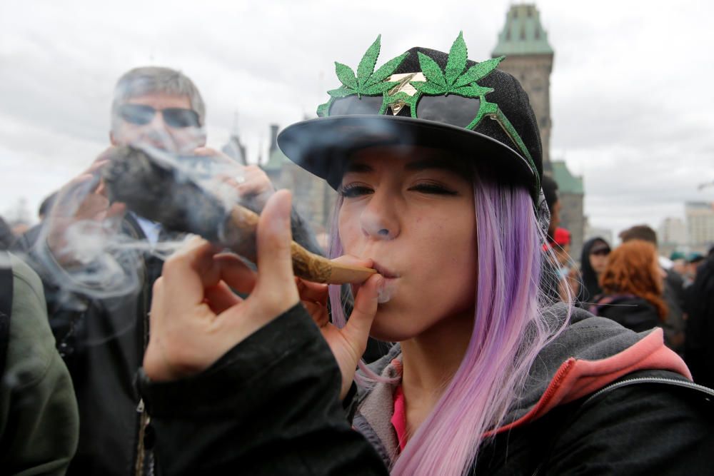 A woman smokes marijuana during the annual 4/20 ...