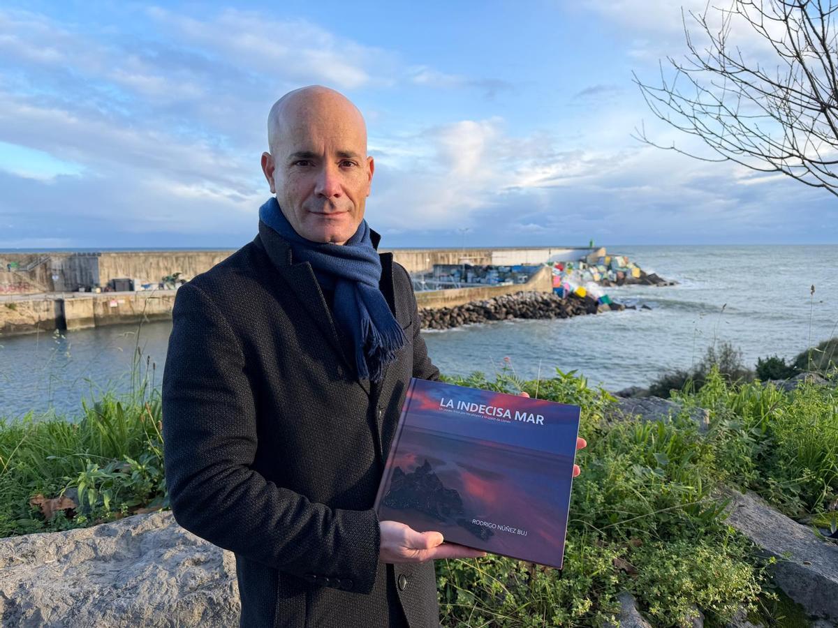 Rodrigo Nuñez con su libro, en El Fuerte, en Llanes.