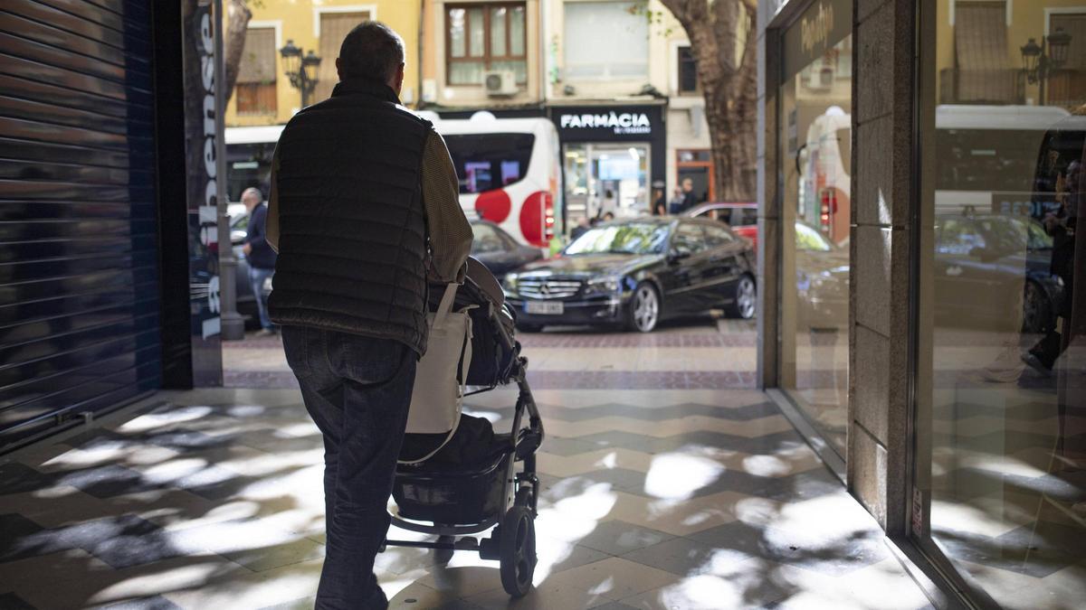 Un padre paseando a su bebé por las calles de Xàtiva.