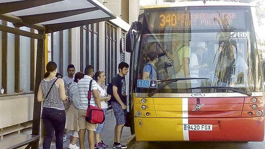 Usuarios suben a un bus en una parada ubicada en el Moll de Pollença.