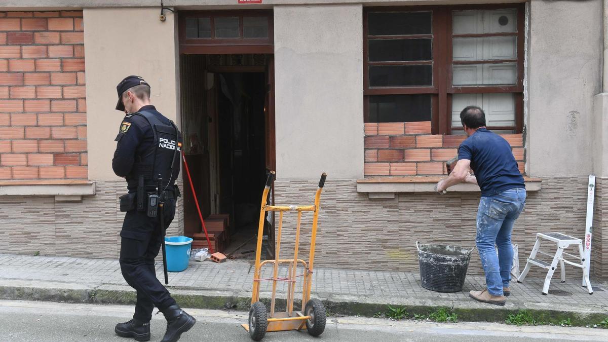 Un policía nacional custodia la entrada a la casa del número 5 de la calle Washington mientras un operario la tapia en la mañana de este miércoles.