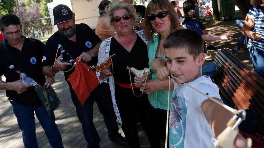 Asistentes a las fiestas del Carbayedo. A la derecha, niños en una zona de juegos infantiles.