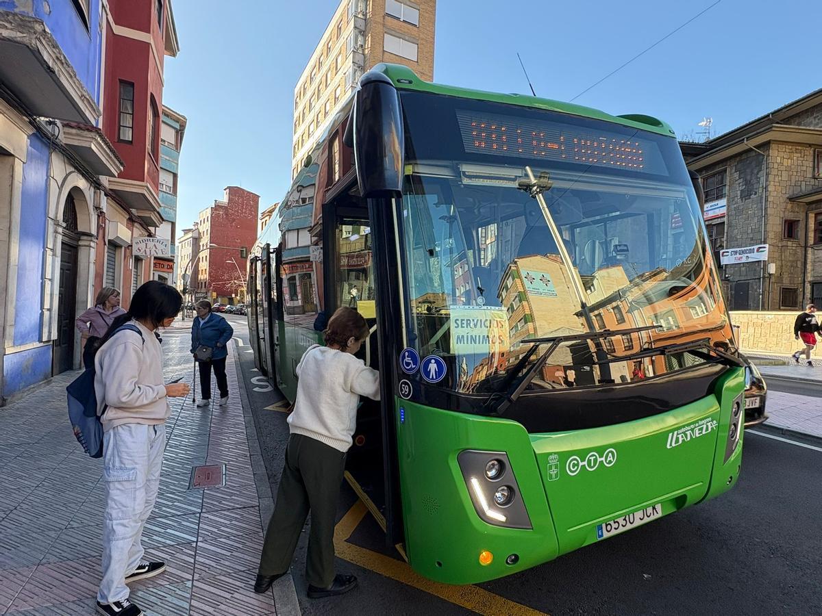 Viajeros subiendo al autobús de servicios mínimos durante la huelga de conductores en el Valle del Nalón