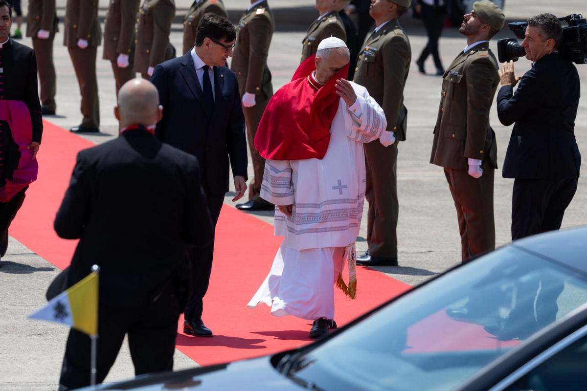 El papa León XIV, a su llegada al aeropuerto de Barcelona. A su lado, Salvador Illa, presidente de la Generalitat, que le ha recibido a pie de avión.