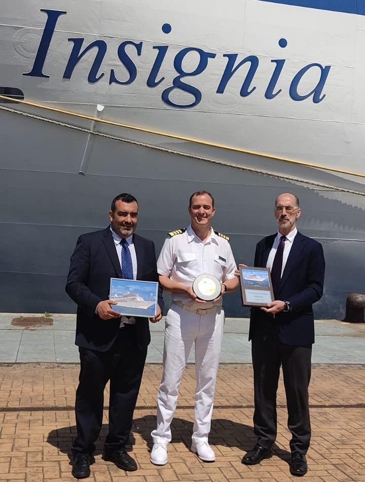 Javier Castro, de la consignataria Incargo Galicia (izq.) posa delante del &quot;Insignia&quot; junto al capitán del crucero y el presidente del Puerto, Jesús Vázquez Almuiña, en la entrega de metopas.