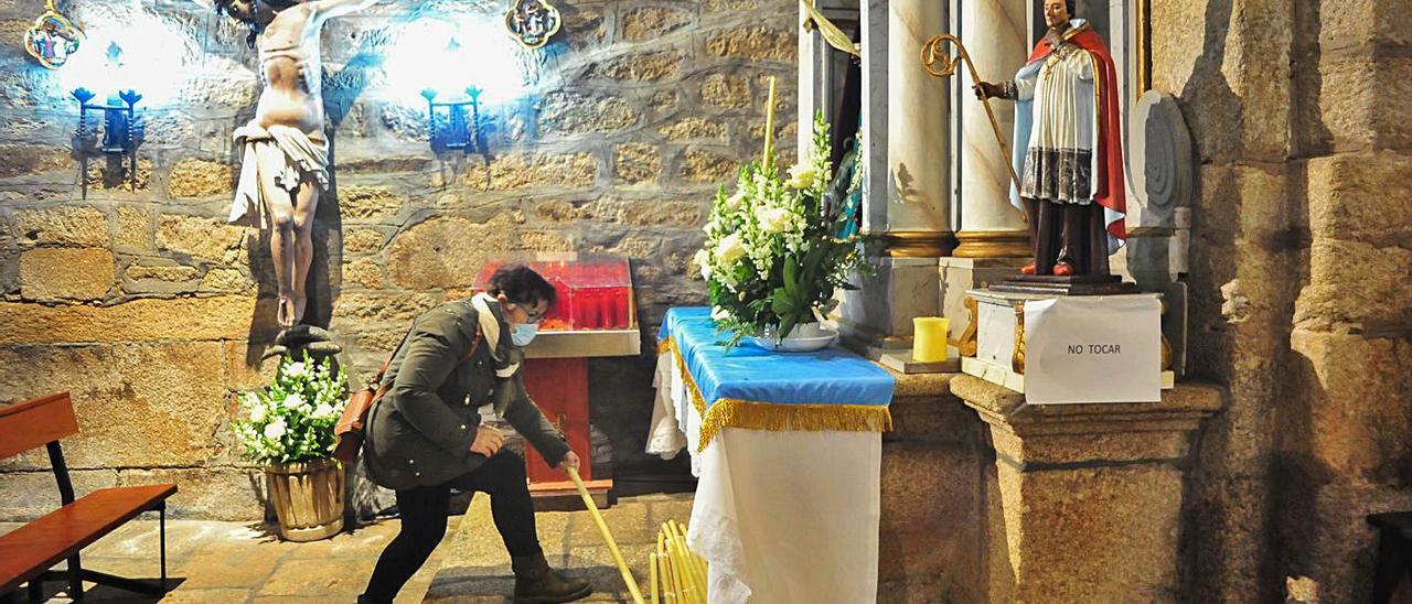 Una feligresa de Cambados deposita un cirio en ofrenda a la Virgen de la Candelaria.   | // IÑAKI ABELLA