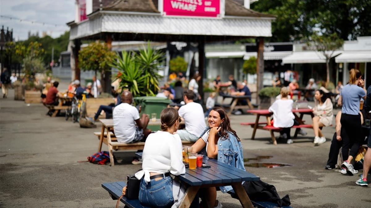 Londinenses toman un refrigerio en una terraza a las orillas del Támesis, este viernes.