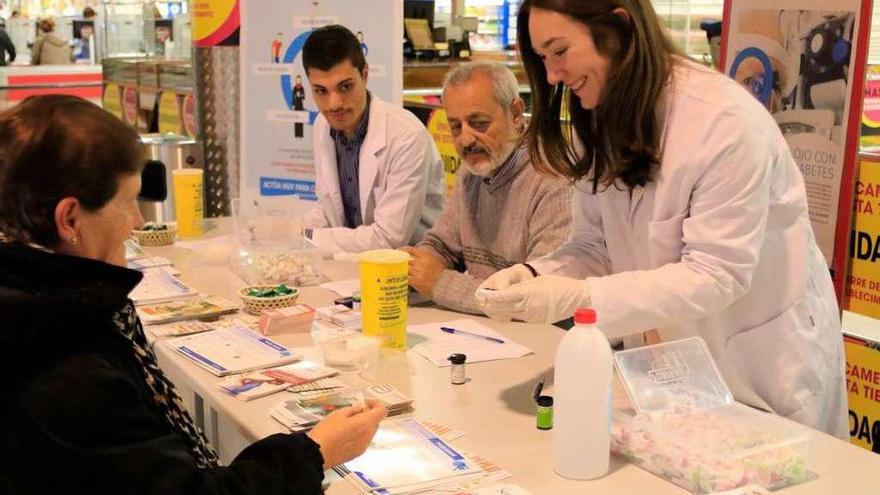 Alumnos de Enfermería realizan una prueba de glucemia a una ciudadana, ayer.