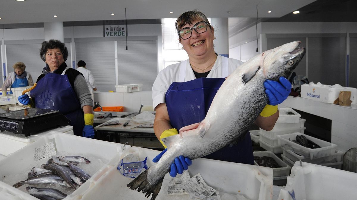 Una pescadera gallega exhibe un ejemplar de salmón.
