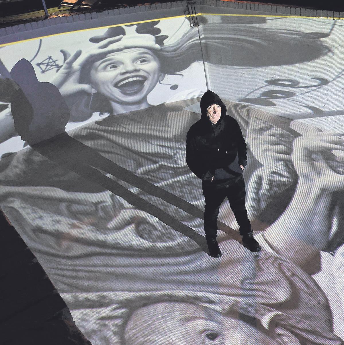 Tomy Ceballos sobre la proyección de una de sus obras digitales