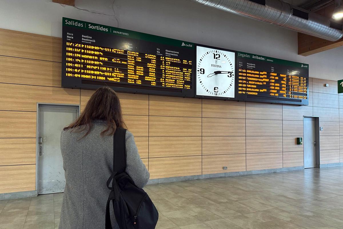 Una dona, a l'estació de Girona, mirant si els AVE surten a l'hora.