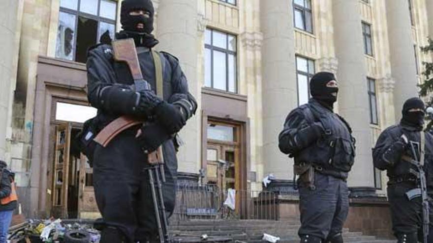 Varios agentes de policía custodian la entrada de un edificio.