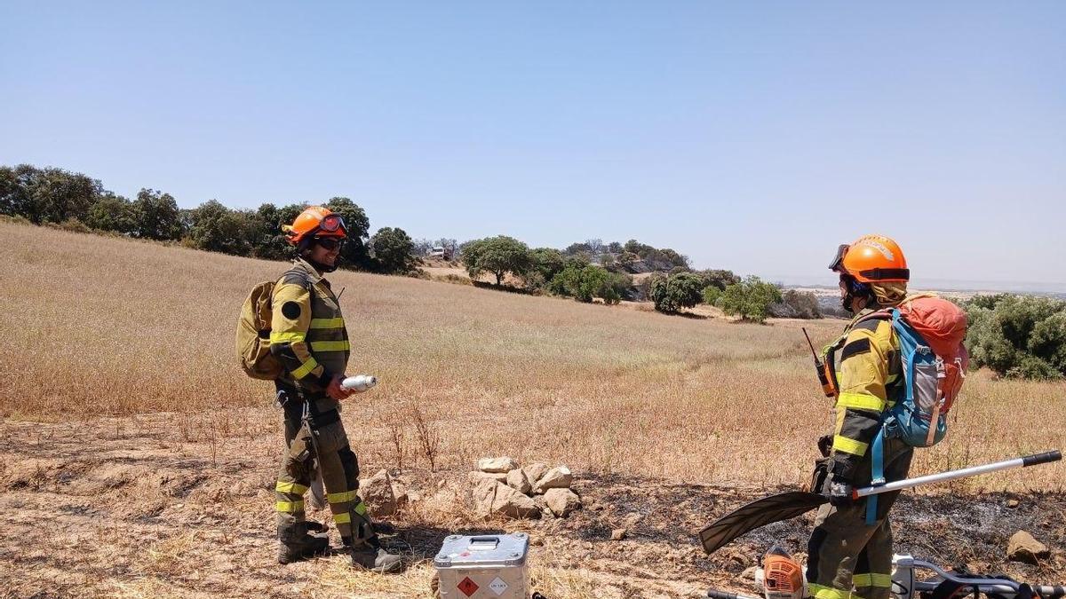 Dos bomberos trabajan sobre el terreno, en campos afectados por el incendio de La Litera.1