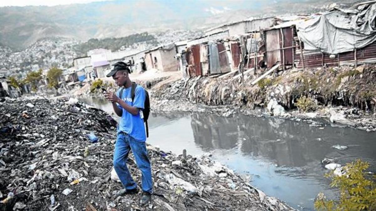 ETIQUETADO. Un hombre fotografía un vertedero en Puerto Príncipe.