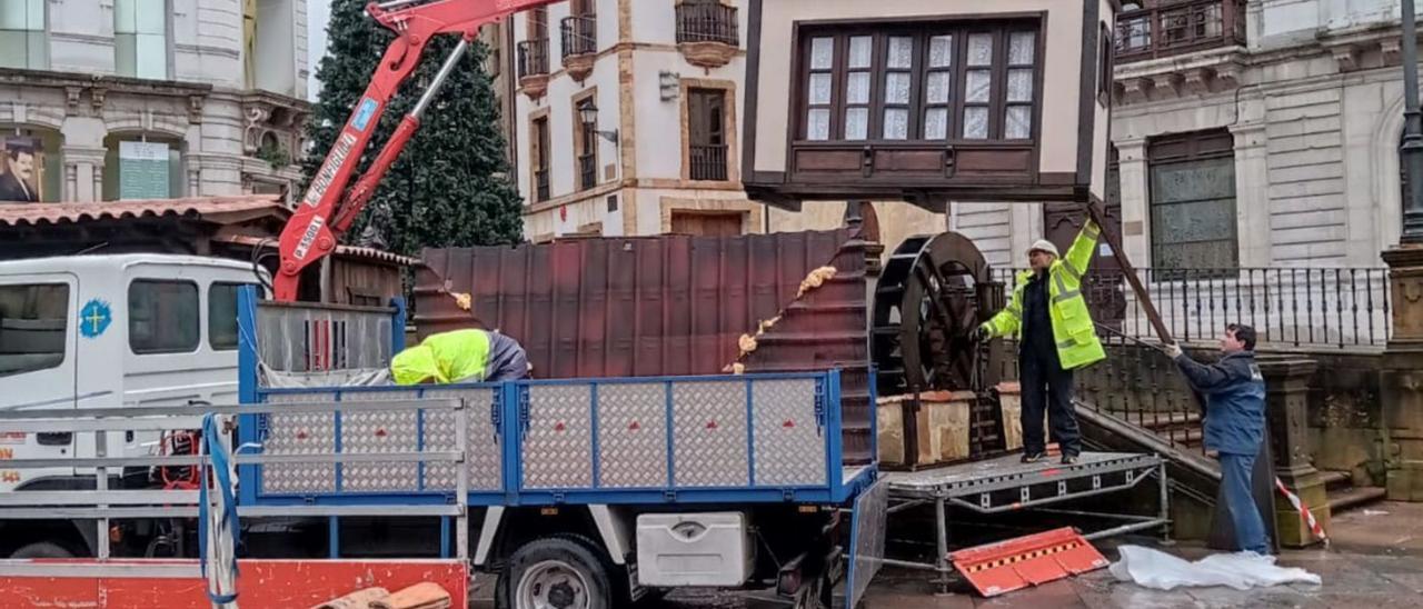 Miembros del colectivo “Como yera antes” instalando el belén de la plaza de la Catedral, ayer. | LNE