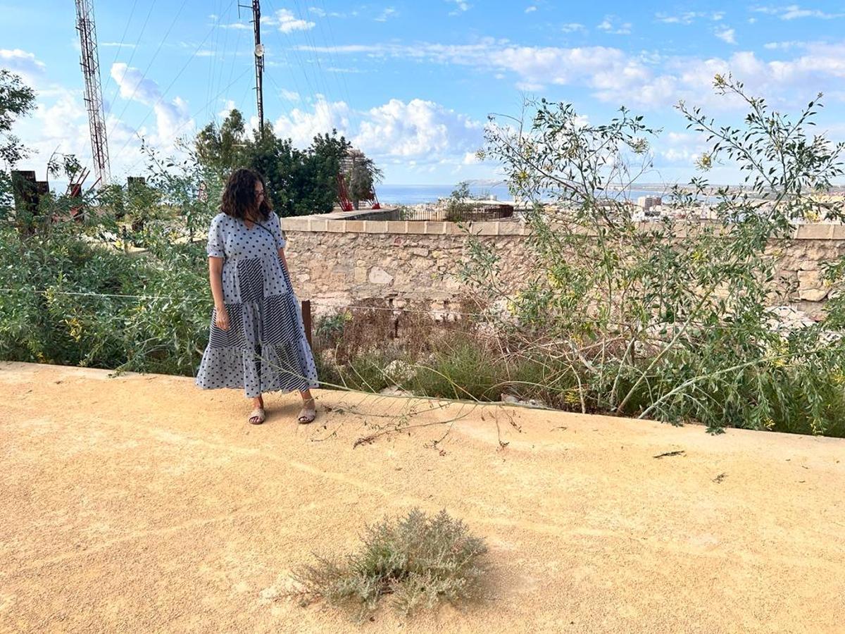 La concejala socialista Trini Amorós, junto a la maleza del castillo de San Fernando