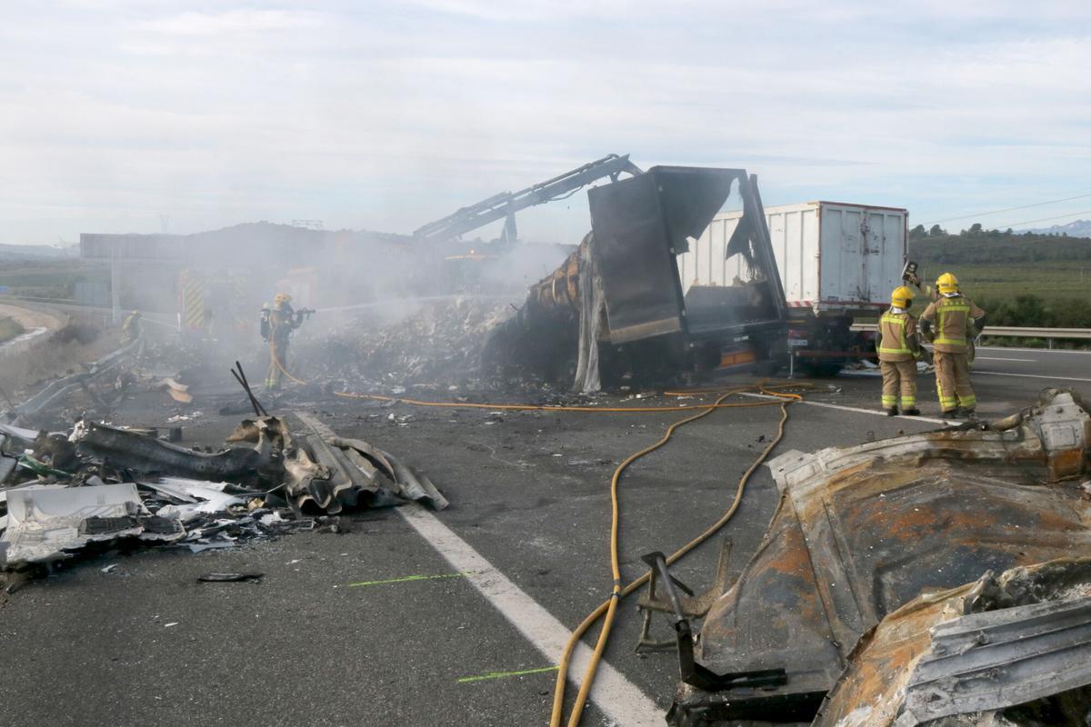 Efectvos de los Bombers de la Generalitat trabajan entre los restos del accidente de tres camions en la AP-7, a l'altura de Aldea, el pasado 11 de noviembre.
