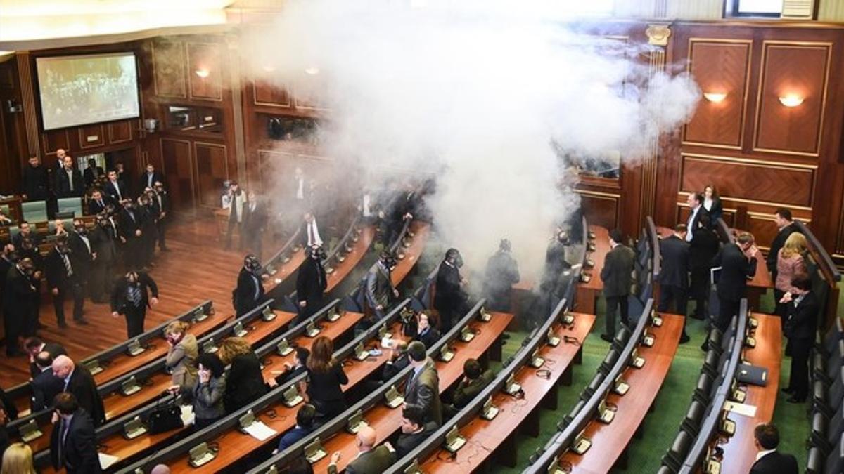 Diputados kosovares evacúan la sala tras el lanzamiento del gas, en la primera sesión parlamentaria del año, en Pristina.