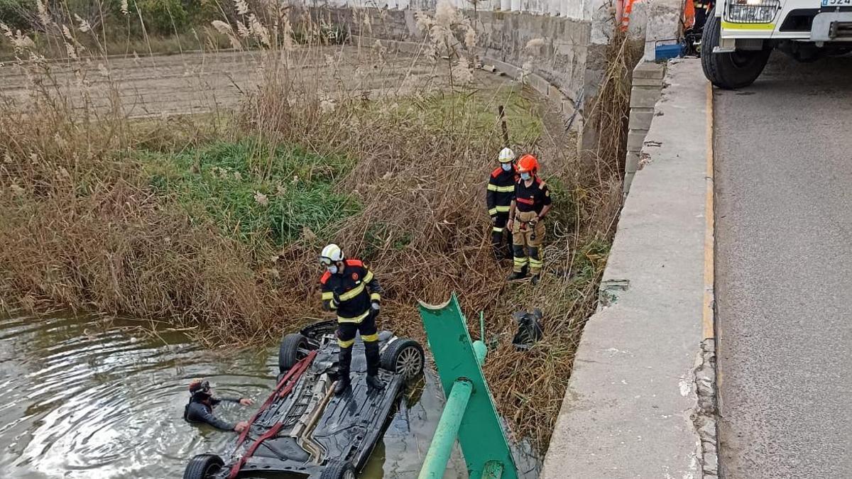 Los bomberos durante las labores de rescate del vehículo.