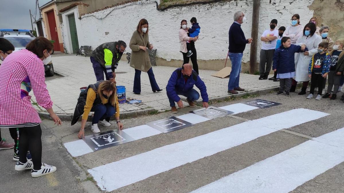 La regidora Elisabeth Martín, con el grupo de padres, niños, profesores y operarios junto a los pictogramas pintados en los pasos de cebra.