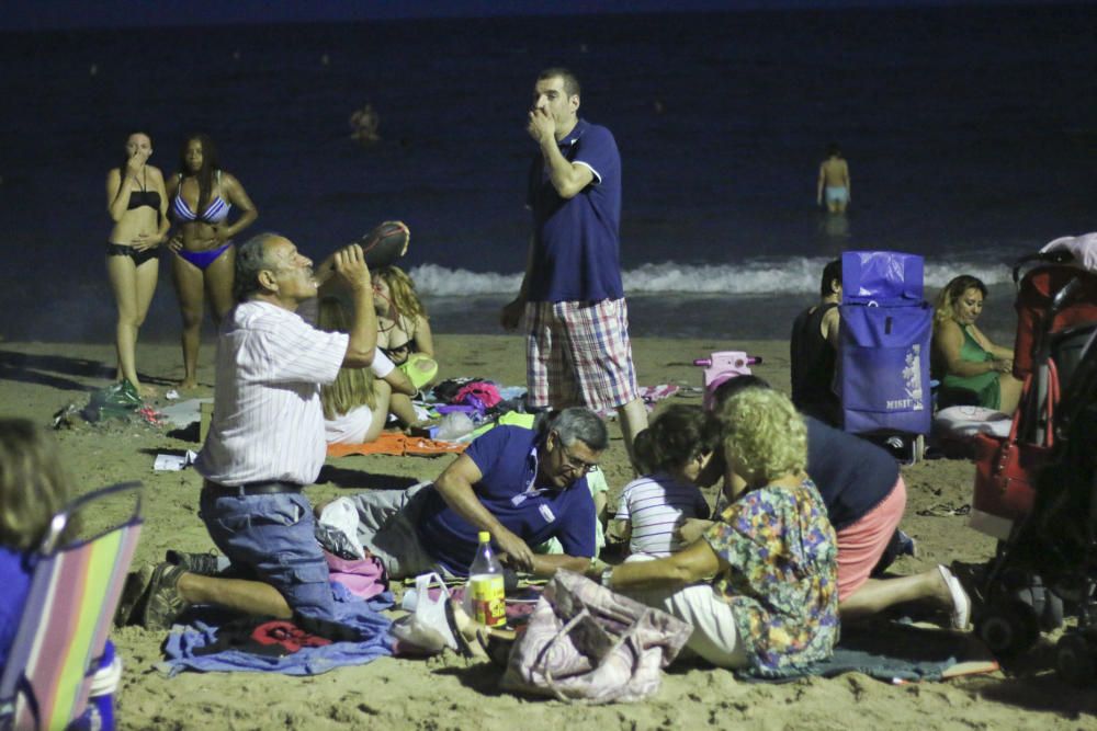 Noche de hogueras, baños, en las playas de la Vega Baja. En las imágenes grupos de amigos y familias en la playa del Cura de Torrevieja