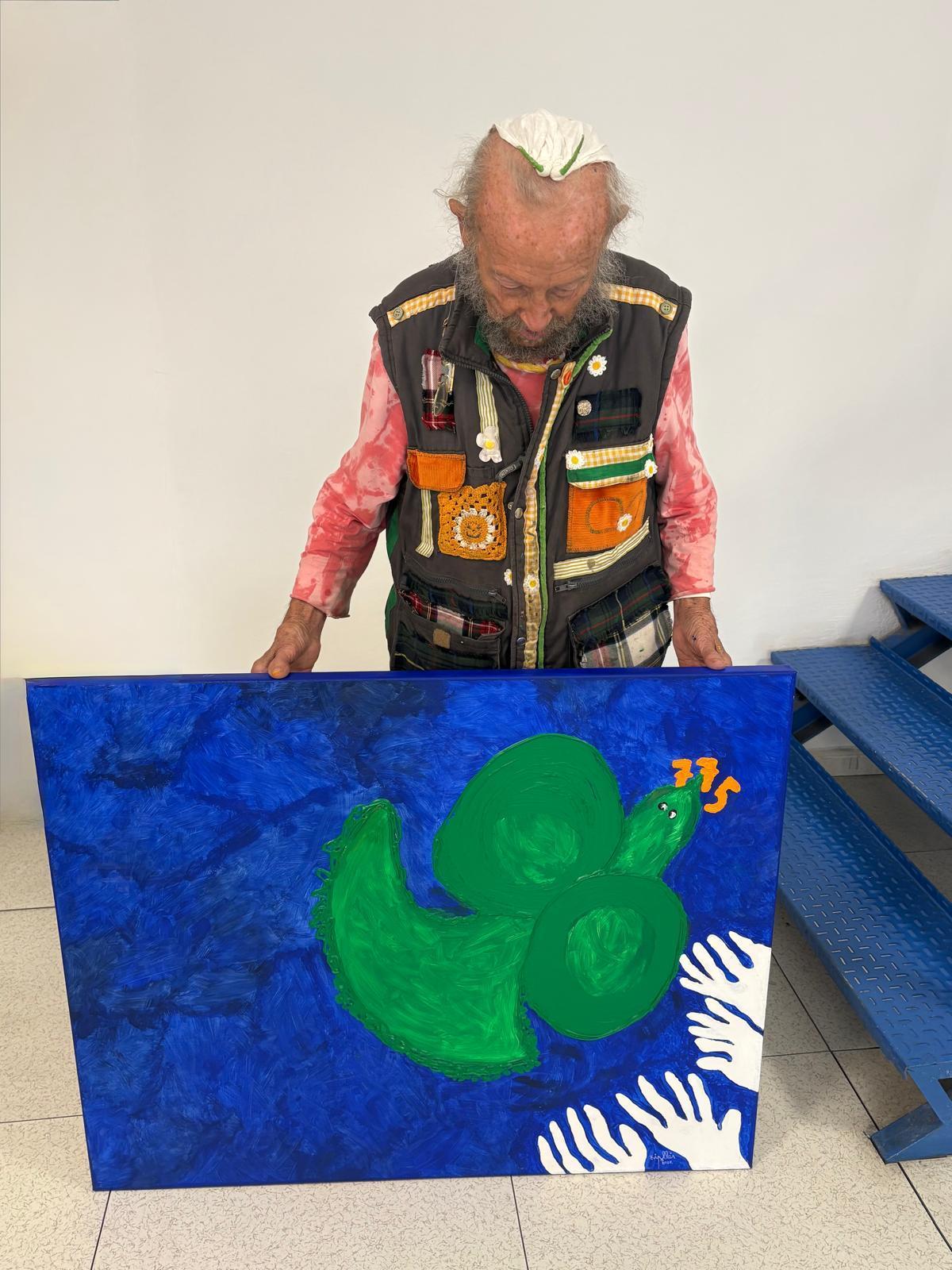 Con la mirada absorta en su obra, ya finalizada.