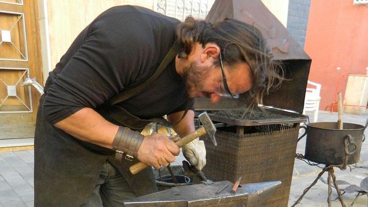 Un herrero demuestra su labor en la fragua.