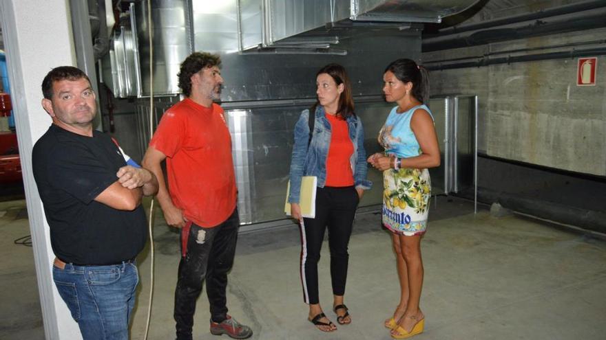 La alcaldesa Nidia Arévalo (derecha) atiende a las explicaciones técnicas en la piscina municipal de Mos. / FdV