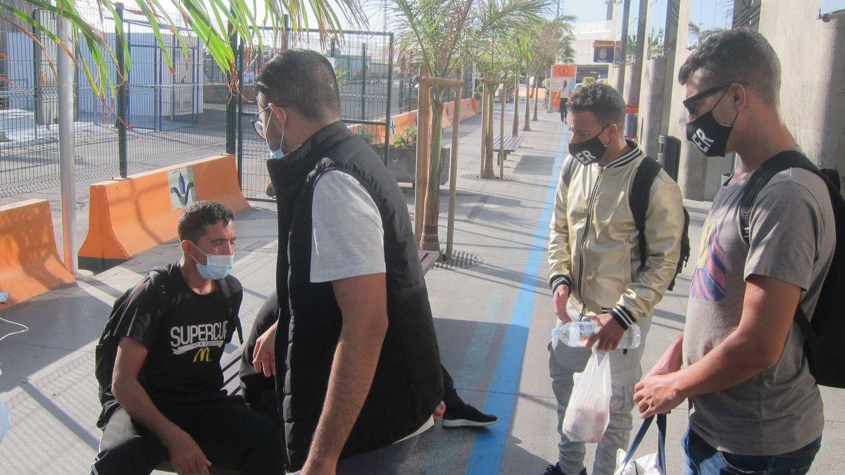 Inmigrantes en el puerto de Santa Cruz esperan la salida de un barco a la Península.