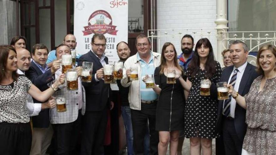 Los asistentes a la presentación del Oktoberfest, ayer, brindando con cerveza en la Casa de la Palmera.