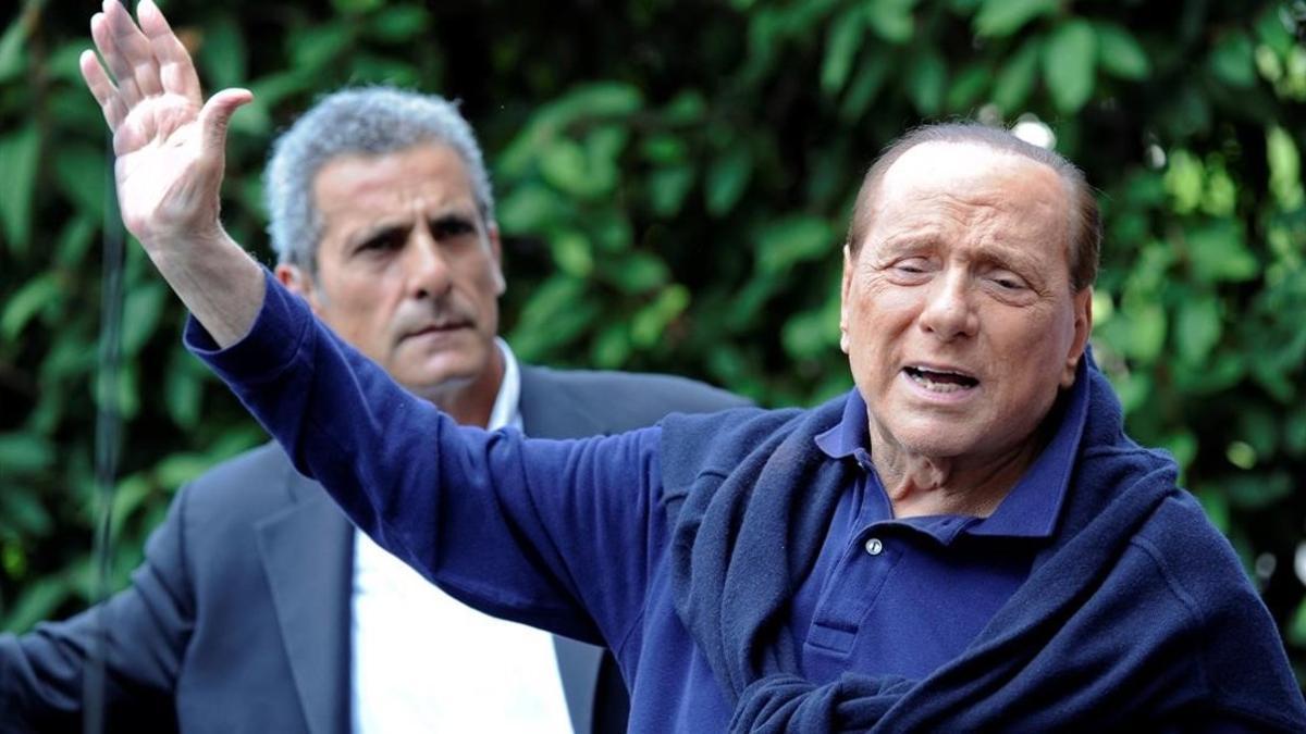 Berlusconi (derecha), al salir del hospital tras operarse del corazón, en Milán, el 5 de julio del 2016.