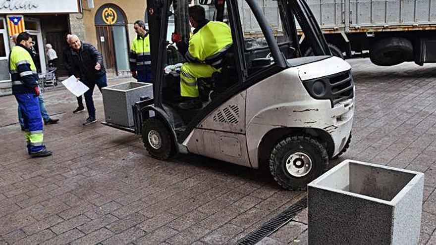 Operaris municipals col·locant el nou mobiliari urbà a la plaça de Sant Pere, ahir