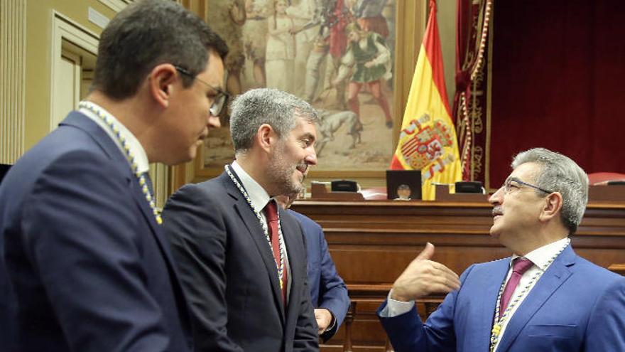 El presidente de Nueva Canarias, Román Rodríguez (d) conversa con el presidente y el vicepresidente en funciones del Gobierno de Canarias, Fernando Clavijo (c), y Pablo Rodríguez, respectivamente, antes de comenzar el pleno de apertura de la X Legislatura.