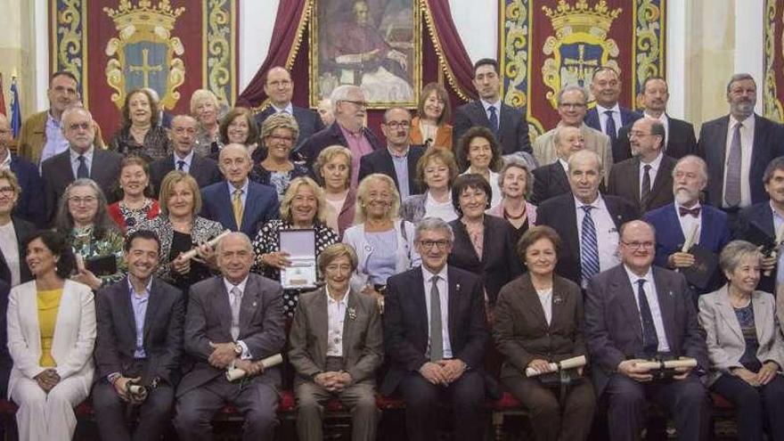 Foto de familia de los galardonados con las insignias de la Universidad con el rector, Santiago García Granda (sentado en el centro).