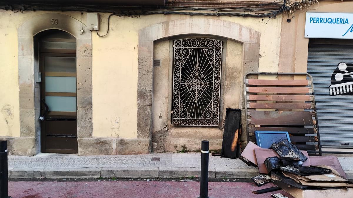 El portal de l'edifici del número 59 del carrer de Circumval·lació, ennegrit pel fum i tancat amb un cadenat