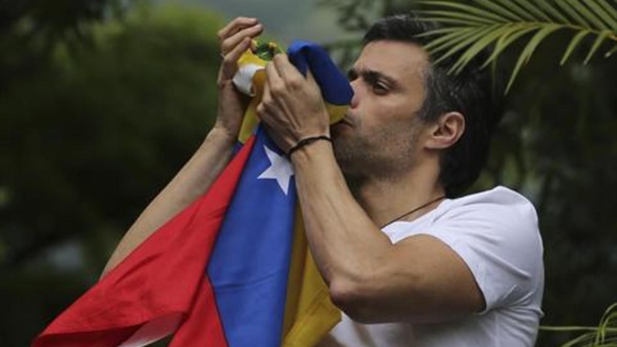 Leopoldo López besa la bandera venezolana tras ser liberado.