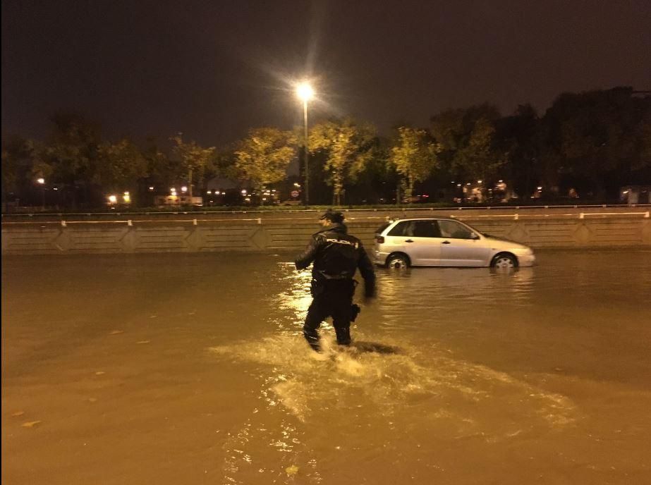 Agentes del Cuerpo Nacional de Policía ayudan a los coches parados por la lluvia en Valencia, anoche.