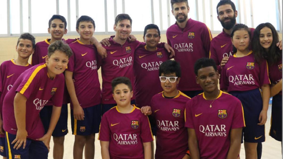 Messi, Turan y Piqué, con los niños