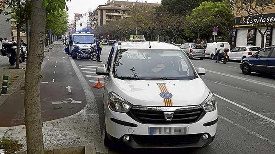 Agentes de la Policía Local junto al taxi interceptado.