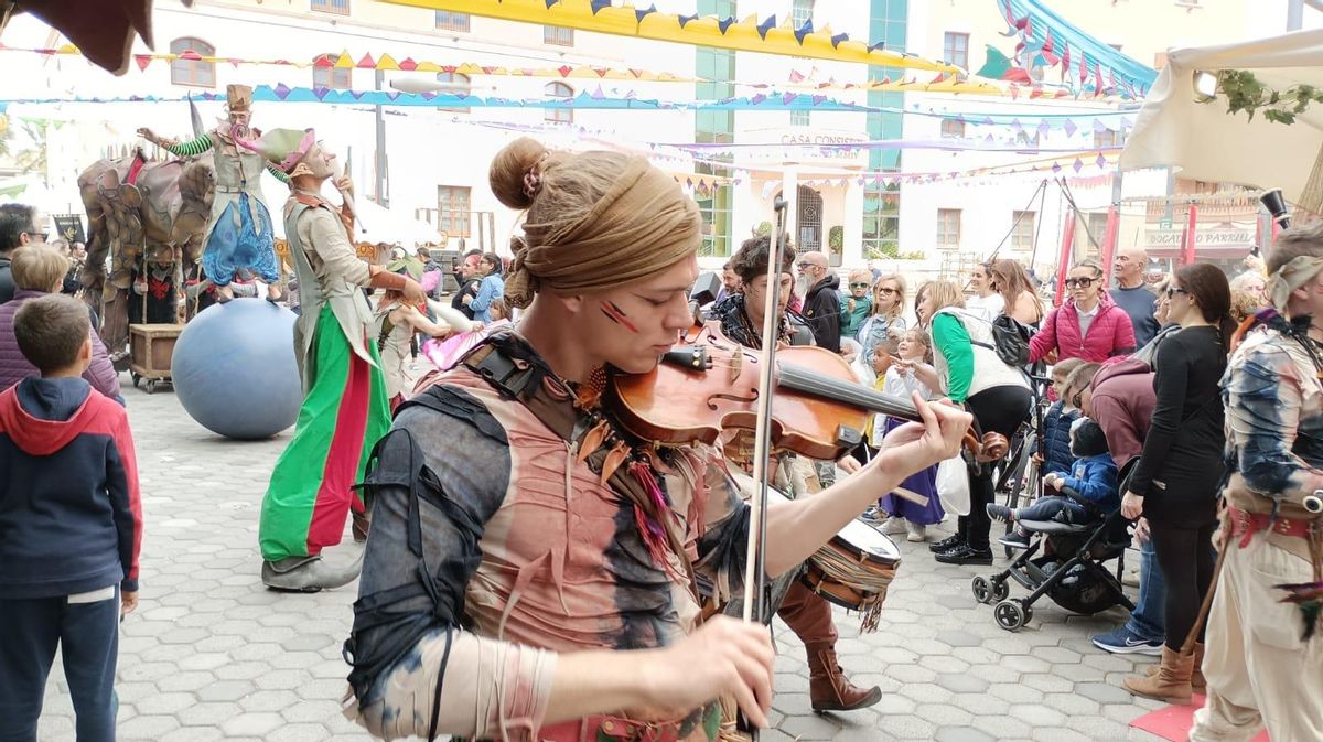 Un hombre vestido de época toca el violín.