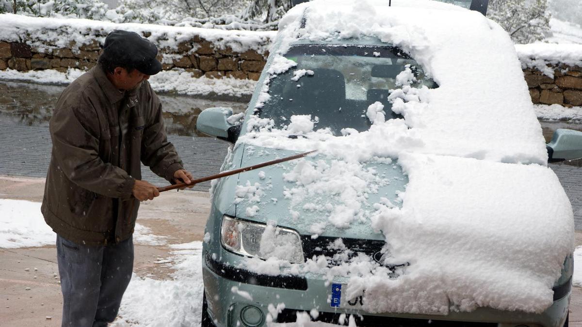 Un hombre intenta retirar la nive de su vehículo