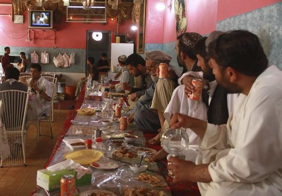 Homes afganesos observen atents els informatius que es fan ressò de la mort d’Ussama bin Laden en un restaurant a Herat (Afganistan).