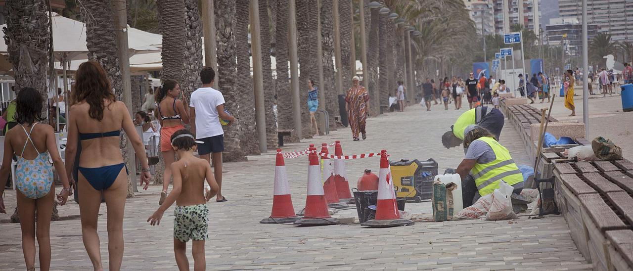 Operarios realizan trabajos de reparación en la avenida de Niza, en el paseo marítimo de la Playa de San Juan, en una imagen de este miércoles.  | PILAR CORTÉS