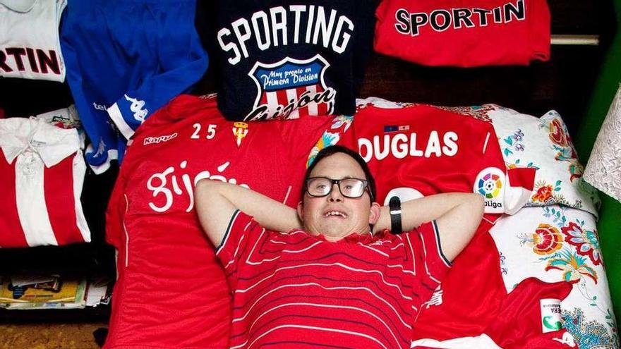Javi Carcedo, tumbado en su cama sobre las camisetas que le han ido regalando los jugadores del Sporting. En el círculo, con las medallas que ha conseguido como nadador.